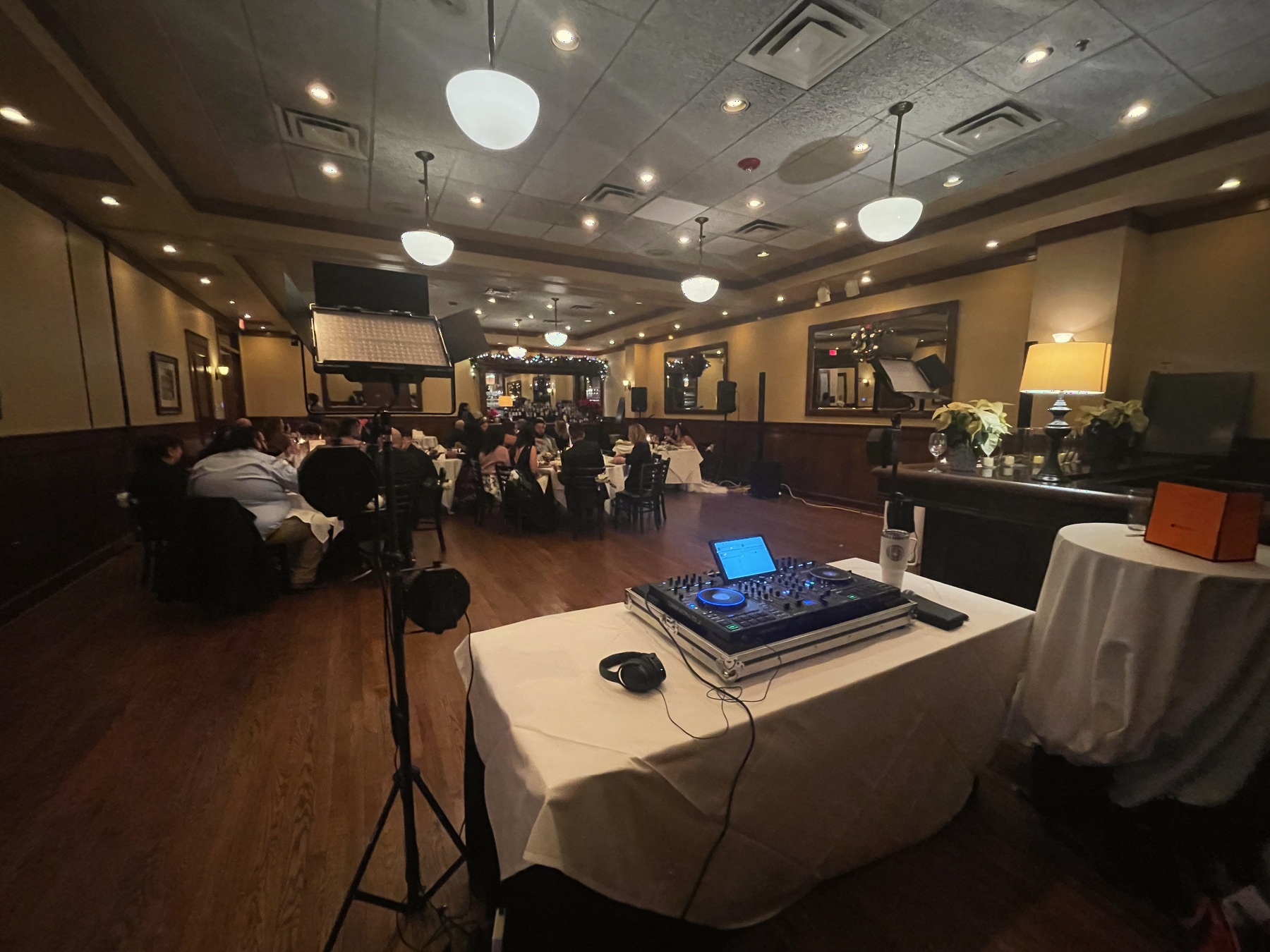 Salón de cena visto desde el setup de DJ con iluminación e invitados