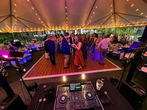 Tented reception dance floor viewed from behind the professional DJ booth