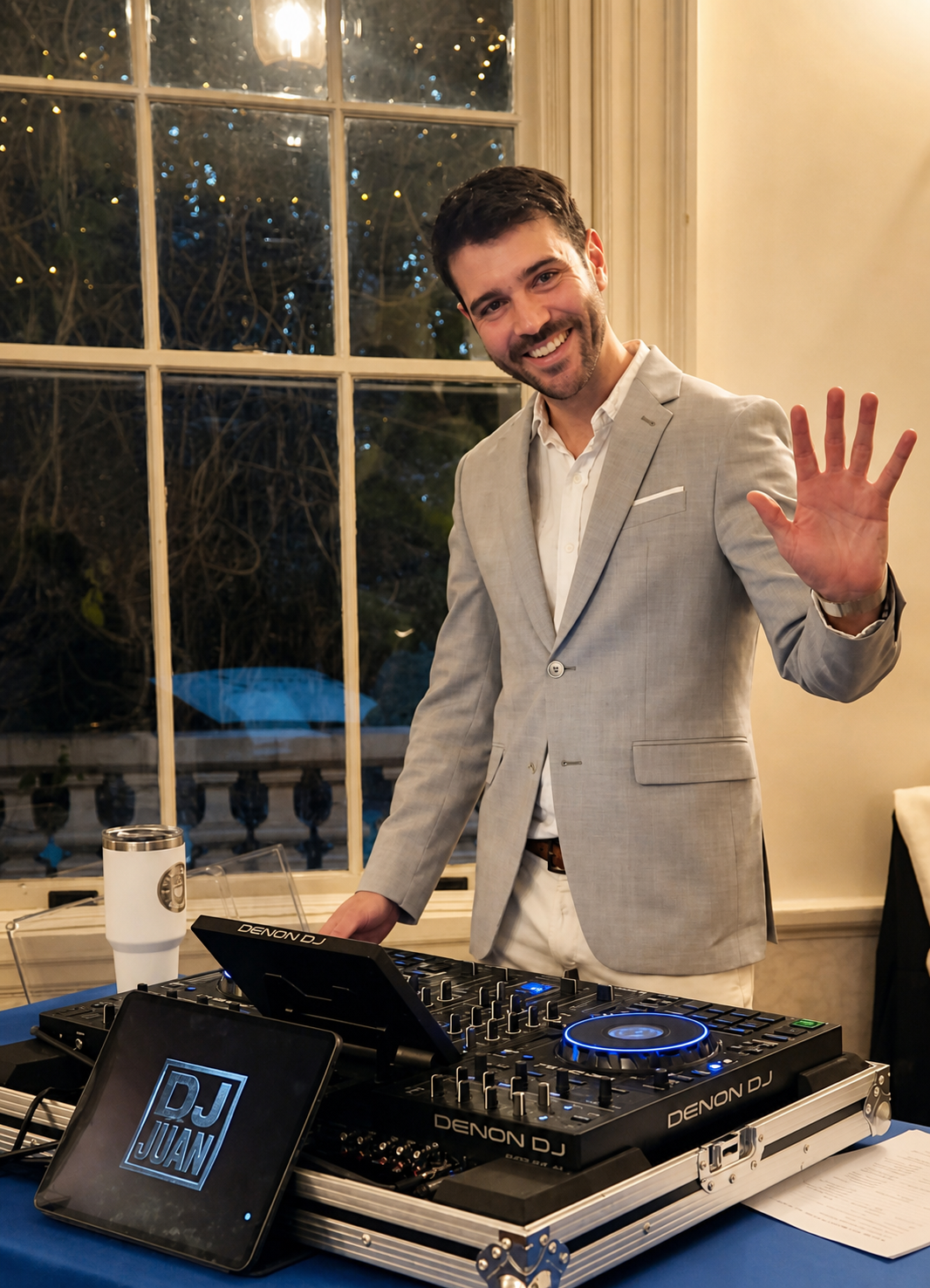 DJ Juan con traje claro detrás de un controlador profesional