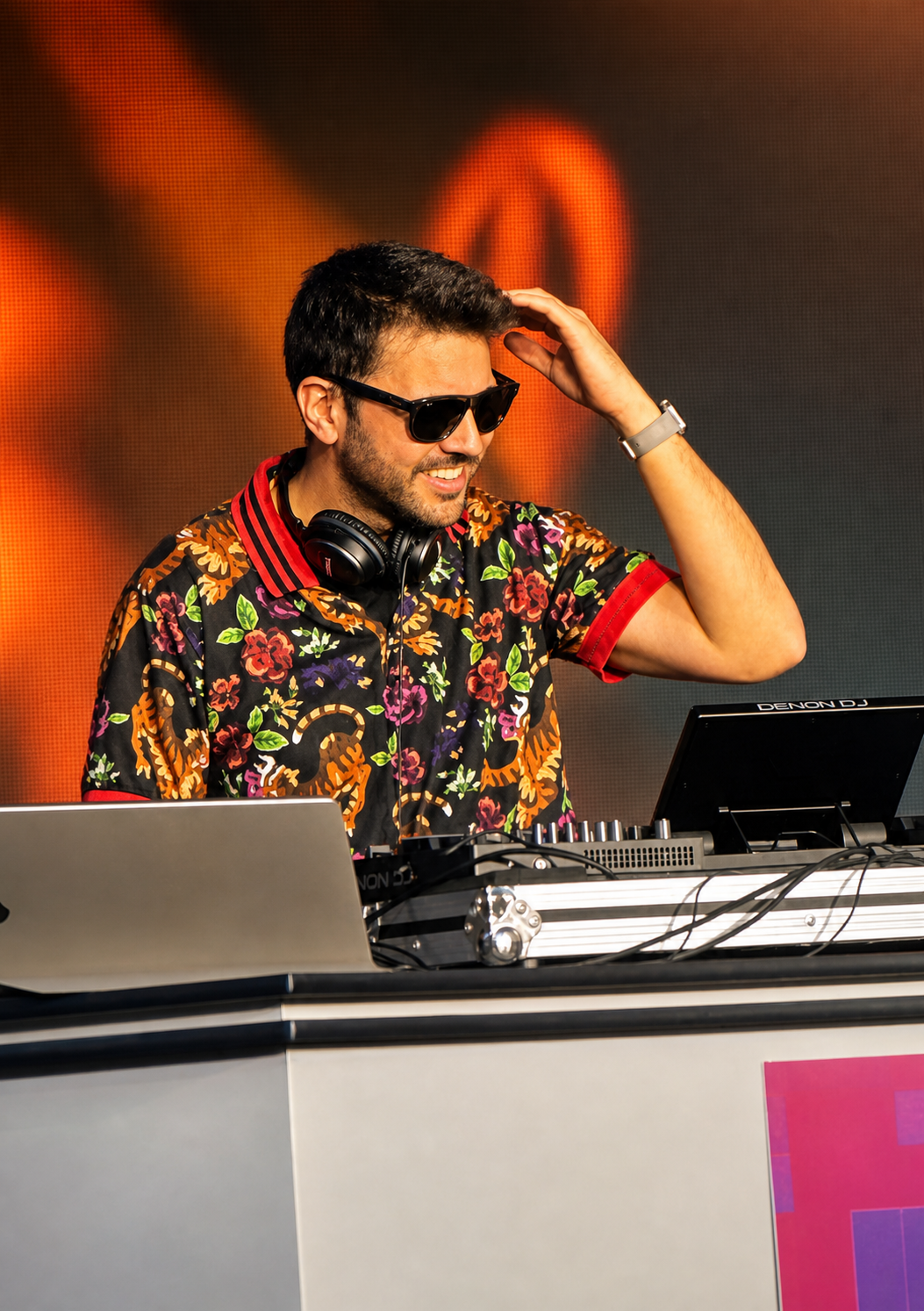 DJ Juan tocando en escenario con luz cálida